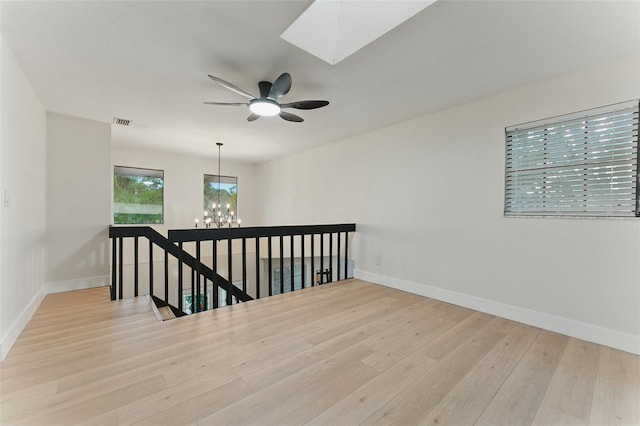 2272 Adam Ct, Palm Harbor, FL 34683 - spare room featuring a chandelier, wood finished floors, a ceiling fan, and a skylight