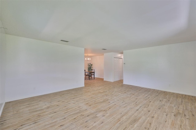 301 Carlyle Blvd, Ruskin, FL 33570 - unfurnished room featuring light wood finished floors and a chandelier