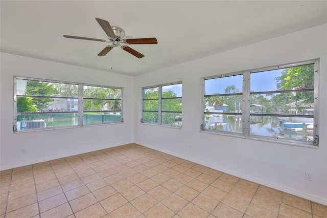 301 Carlyle Blvd, Ruskin, FL 33570 - empty room with a ceiling fan, a water view, and light tile patterned floors