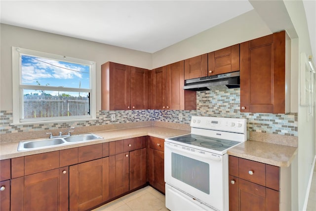 11896 104th Ln, Largo, FL 33773 - kitchen with white electric range, under cabinet range hood, light countertops, backsplash, and light tile patterned flooring