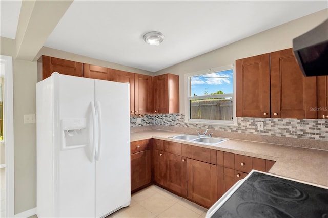 11896 104th Ln, Largo, FL 33773 - kitchen featuring white refrigerator with ice dispenser, range hood, decorative backsplash, brown cabinets, and light countertops