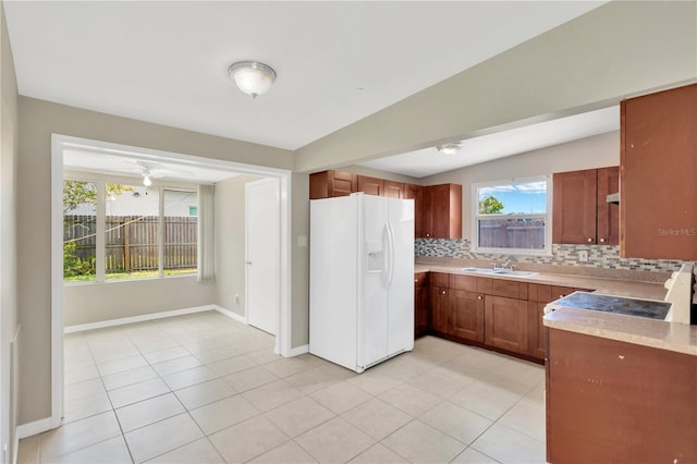 11896 104th Ln, Largo, FL 33773 - kitchen featuring white fridge with ice dispenser, backsplash, light countertops, and brown cabinetry