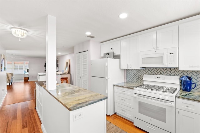 3018 59th St S Unit 405, Gulfport, FL 33707 - kitchen with white appliances, a kitchen island, white cabinetry, and recessed lighting