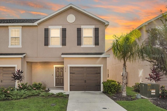 1218 Grantham Dr, Sarasota, FL 34234 - view of front facade featuring stucco siding, a garage, driveway, and a lawn