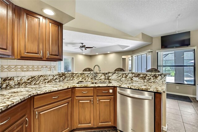 10721 N Ocean Dr, Dunnellon, FL 34434 - kitchen with stainless steel dishwasher, a textured ceiling, a ceiling fan, light stone counters, and decorative backsplash