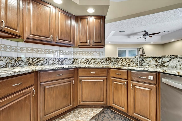 10721 N Ocean Dr, Dunnellon, FL 34434 - kitchen with stainless steel dishwasher, backsplash, light stone countertops, ceiling fan, and a textured ceiling