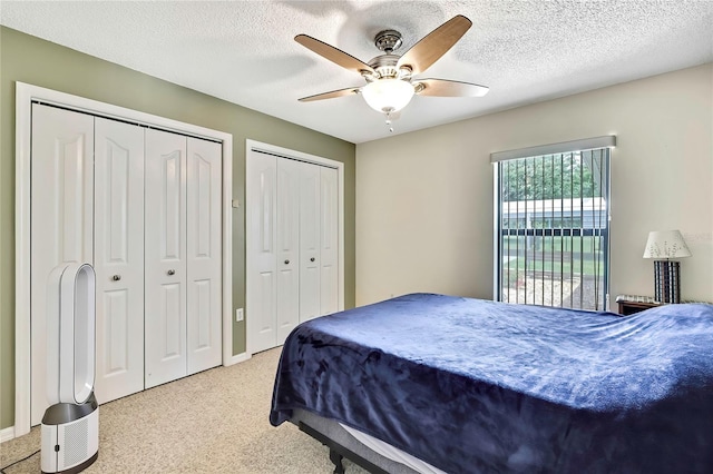10721 N Ocean Dr, Dunnellon, FL 34434 - carpeted bedroom with two closets, ceiling fan, and a textured ceiling