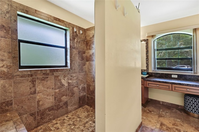 10721 N Ocean Dr, Dunnellon, FL 34434 - bathroom with healthy amount of natural light, a tile shower, and stone finish flooring