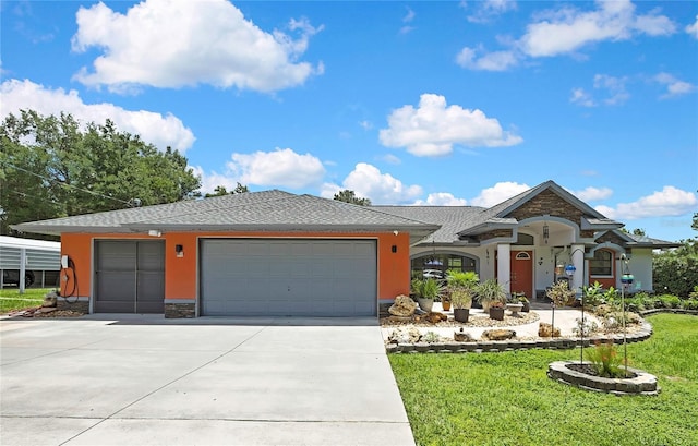 10721 N Ocean Dr, Dunnellon, FL 34434 - view of front of home featuring an attached garage, a front yard, driveway, roof with shingles, and stucco siding