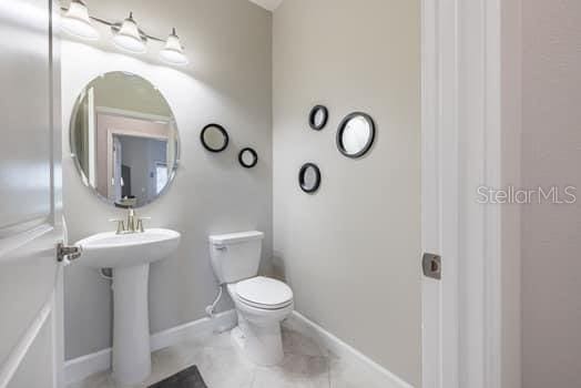 28504 Tranquil Lake Cir, Wesley Chapel, FL 33543 - half bath with toilet and tile patterned flooring
