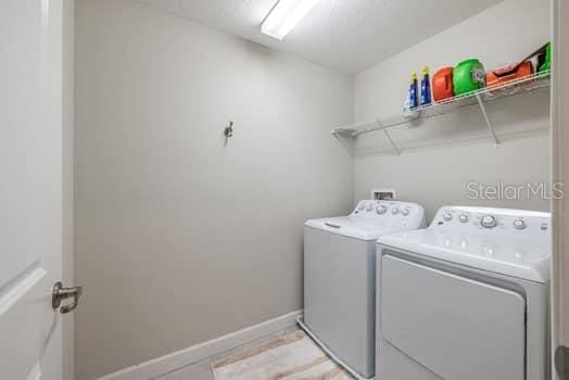28504 Tranquil Lake Cir, Wesley Chapel, FL 33543 - washroom with separate washer and dryer and baseboards