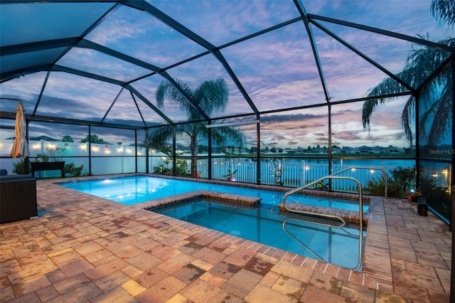 31244 Baclan Dr, Wesley Chapel, FL 33545 - pool at dusk with a patio area, a pool with connected hot tub, glass enclosure, and a water view