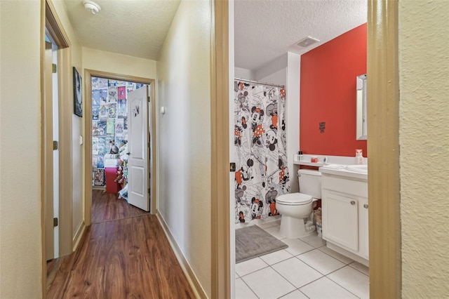 31244 Baclan Dr, Wesley Chapel, FL 33545 - bathroom featuring vanity, a textured ceiling, a shower with shower curtain, and wood finished floors