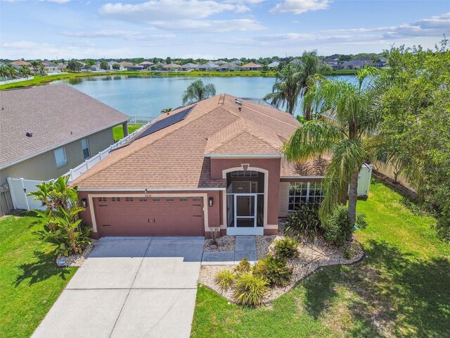 31244 Baclan Dr, Wesley Chapel, FL 33545 - view of front of home featuring an attached garage, stucco siding, a water view, and concrete driveway
