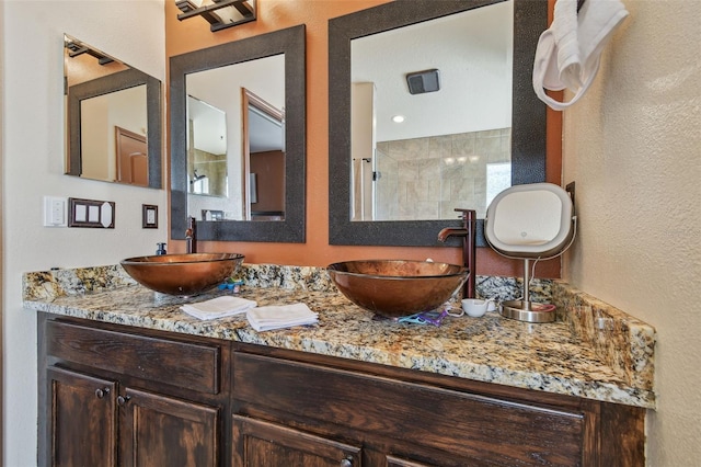 31244 Baclan Dr, Wesley Chapel, FL 33545 - full bath featuring double vanity, a textured wall, and a tile shower
