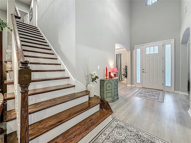 33668 Willow Point Ct, Wesley Chapel, FL 33545 - foyer entrance featuring arched walkways, a towering ceiling, stairway, and wood finished floors