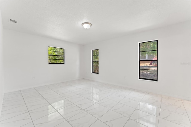 10237 Carrin Rd, Spring Hill, FL 34608 - unfurnished room featuring marble look tile flooring and a textured ceiling