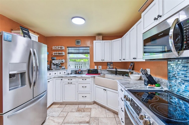 1910 Montego Ct, Oldsmar, FL 34677 - kitchen with appliances with stainless steel finishes, white cabinetry, stone tile floors, and light countertops