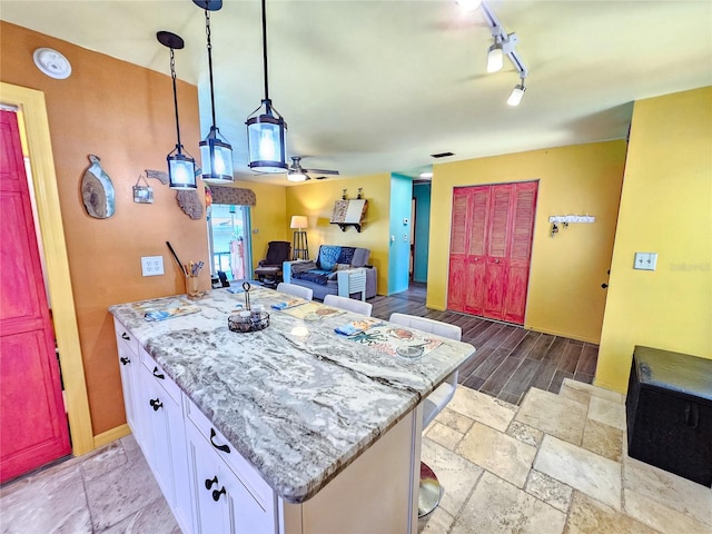 1910 Montego Ct, Oldsmar, FL 34677 - kitchen featuring white cabinetry, a peninsula, ceiling fan, light stone countertops, and open floor plan