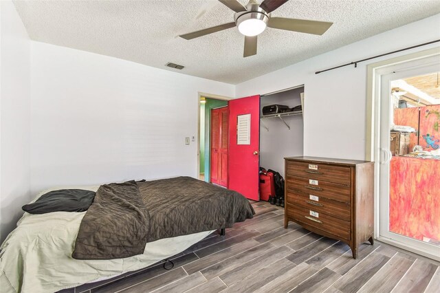 1910 Montego Ct, Oldsmar, FL 34677 - bedroom featuring wood finished floors, a textured ceiling, a closet, and a ceiling fan
