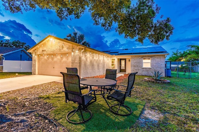 1910 Montego Ct, Oldsmar, FL 34677 - back of house with stone siding, a garage, roof mounted solar panels, concrete driveway, and a gate