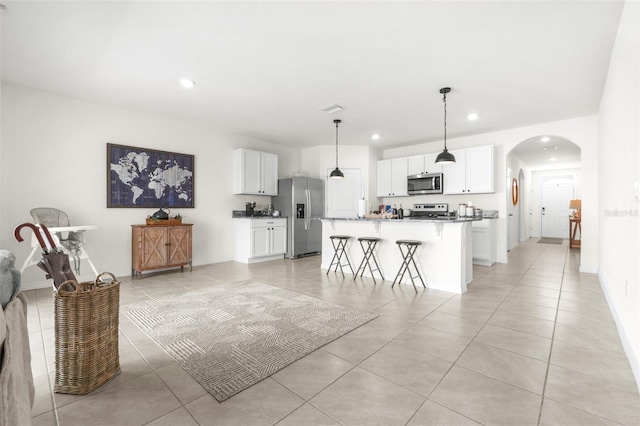 9098 Forge Breeze Loop, Wesley Chapel, FL 33545 - living room with light tile patterned flooring, recessed lighting, and arched walkways