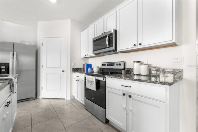 9098 Forge Breeze Loop, Wesley Chapel, FL 33545 - kitchen with appliances with stainless steel finishes, white cabinets, dark stone counters, and light tile patterned floors