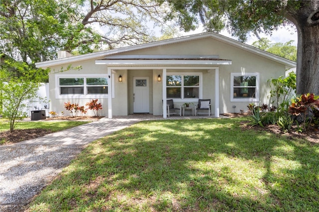 615 6th Ave N, Safety Harbor, FL 34695 - view of front facade with covered porch, a front yard, and stucco siding