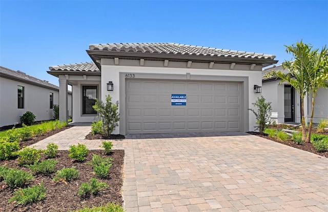 6133 Wire Grass Ct, Nokomis, FL 34275 - mediterranean / spanish-style home with decorative driveway, stucco siding, an attached garage, and a tiled roof