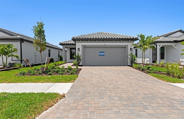 6133 Wire Grass Ct, Nokomis, FL 34275 - view of front of house featuring decorative driveway, a garage, stucco siding, and a tiled roof