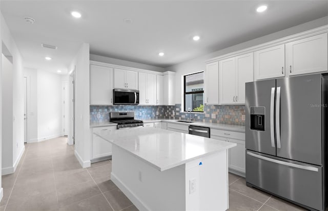 6133 Wire Grass Ct, Nokomis, FL 34275 - kitchen featuring stainless steel appliances, backsplash, a kitchen island, white cabinetry, and recessed lighting