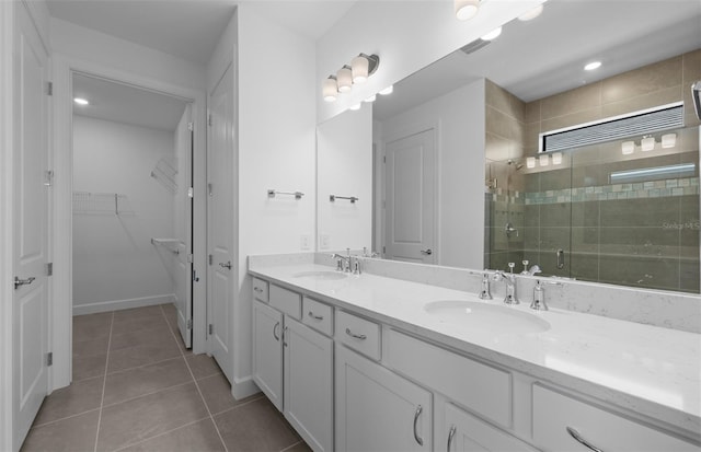 6133 Wire Grass Ct, Nokomis, FL 34275 - bathroom featuring a stall shower, double vanity, tile patterned flooring, and a spacious closet