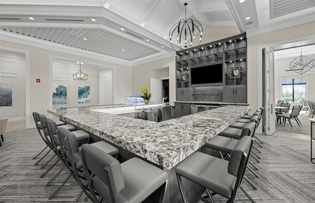 6133 Wire Grass Ct, Nokomis, FL 34275 - kitchen featuring a chandelier, recessed lighting, a spacious island, light carpet, and light stone countertops