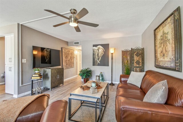8080 112th St Unit 108, Seminole, FL 33772 - living room featuring wood finished floors, a ceiling fan, and a textured ceiling