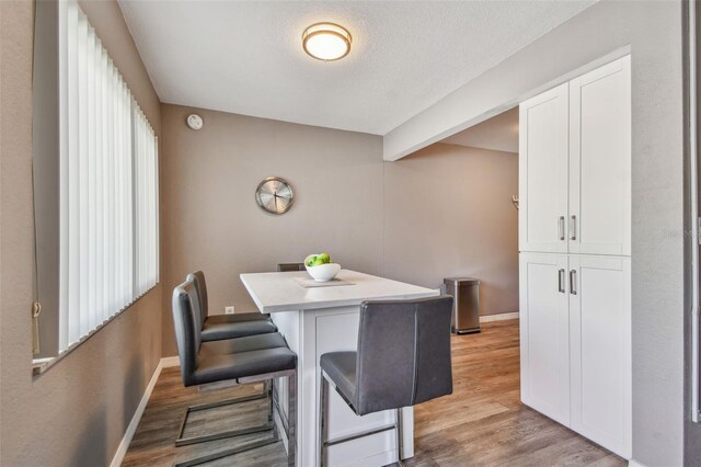 8080 112th St Unit 108, Seminole, FL 33772 - dining area featuring light wood-type flooring and a textured ceiling
