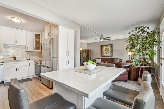 8080 112th St Unit 108, Seminole, FL 33772 - kitchen featuring light wood-type flooring, open floor plan, freestanding refrigerator, and ceiling fan