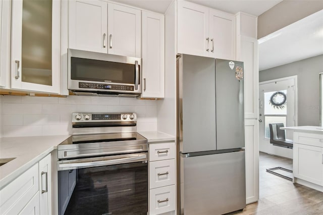 8080 112th St Unit 108, Seminole, FL 33772 - kitchen with stainless steel appliances, light countertops, tasteful backsplash, and white cabinets