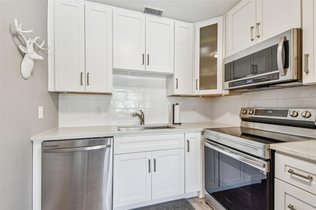 8080 112th St Unit 108, Seminole, FL 33772 - kitchen featuring appliances with stainless steel finishes, tasteful backsplash, light countertops, and white cabinetry