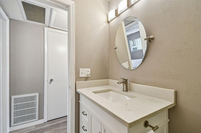 8080 112th St Unit 108, Seminole, FL 33772 - bathroom with vanity, wood finished floors, and a textured wall