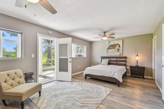 8080 112th St Unit 108, Seminole, FL 33772 - bedroom with access to exterior, wood finished floors, a textured ceiling, and ceiling fan