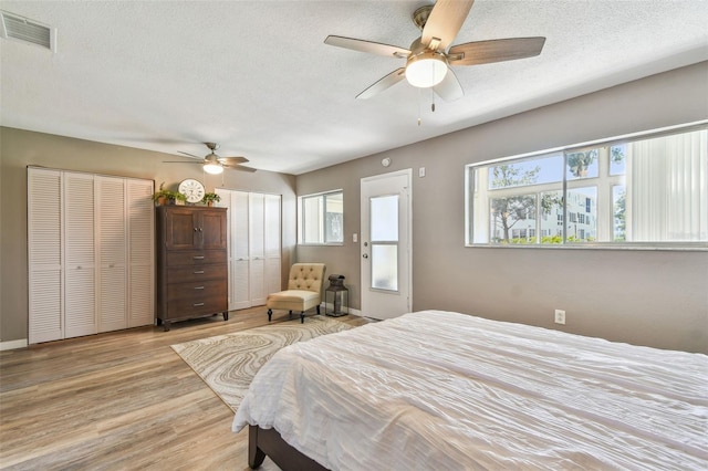 8080 112th St Unit 108, Seminole, FL 33772 - bedroom featuring multiple closets, wood finished floors, a textured ceiling, and a ceiling fan