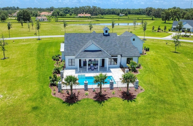 12902 SW 138th Loop, Dunnellon, FL 34432 - rear view of property featuring a water view, a yard, a patio area, an outdoor pool, and a shingled roof