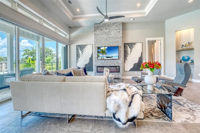 12902 SW 138th Loop, Dunnellon, FL 34432 - living room with a ceiling fan, a fireplace, a tray ceiling, recessed lighting, and ornamental molding