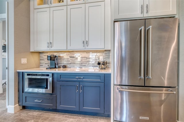 12902 SW 138th Loop, Dunnellon, FL 34432 - kitchen with stainless steel appliances, light countertops, tasteful backsplash, blue cabinets, and glass insert cabinets