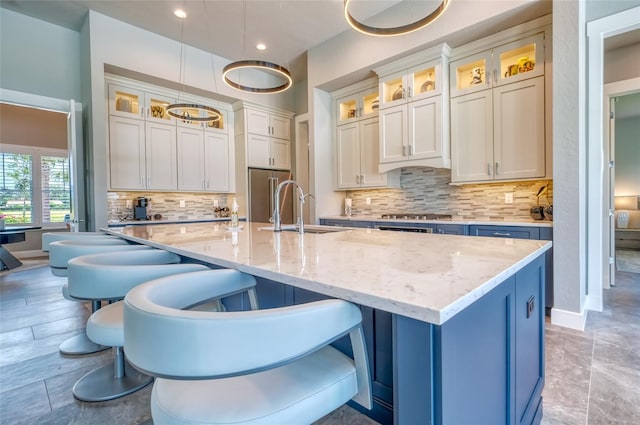 12902 SW 138th Loop, Dunnellon, FL 34432 - kitchen with a kitchen bar, a kitchen island with sink, tasteful backsplash, white cabinets, and recessed lighting