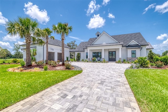 12902 SW 138th Loop, Dunnellon, FL 34432 - modern farmhouse style home with a standing seam roof, french doors, decorative driveway, a front lawn, and a metal roof