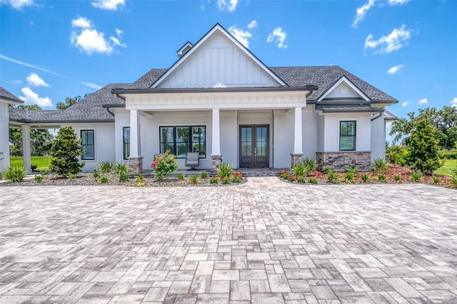 12902 SW 138th Loop, Dunnellon, FL 34432 - view of front of home featuring french doors, covered porch, stucco siding, board and batten siding, and stone siding