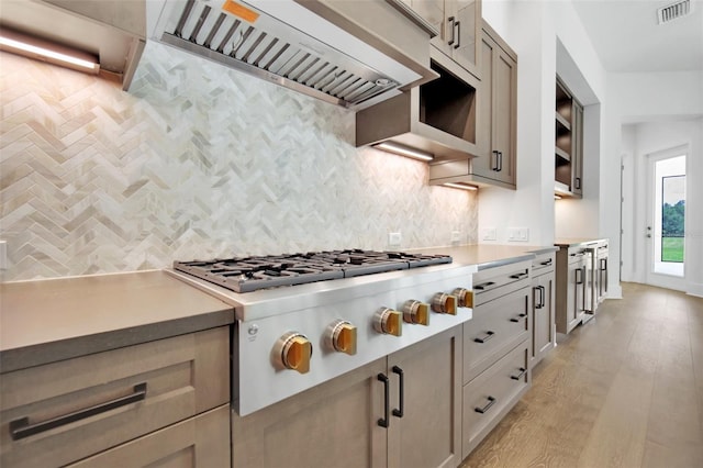 937 Old Welcome Rd, Lithia, FL 33547 - kitchen with custom range hood, stainless steel gas stovetop, light countertops, decorative backsplash, and light wood-style floors