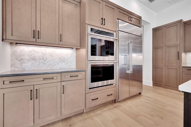 937 Old Welcome Rd, Lithia, FL 33547 - kitchen featuring appliances with stainless steel finishes, light wood-type flooring, backsplash, and light countertops