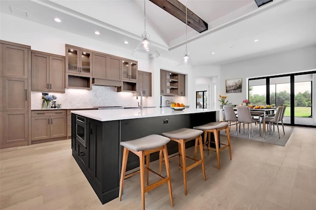 937 Old Welcome Rd, Lithia, FL 33547 - kitchen with light countertops, decorative backsplash, recessed lighting, a large island, and light wood-style floors